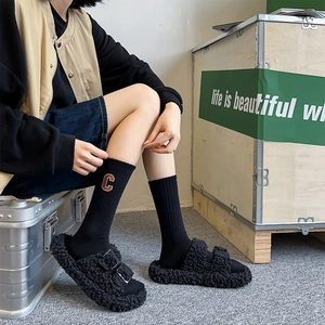 Chic black fleece slippers with silver buckles and mid-calf socks featuring letter C embroidery