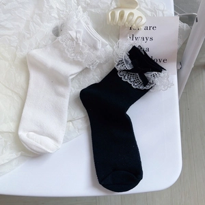 Détail de chaussettes Lolita avec dentelle délicate et nœuds mignons en noir et blanc