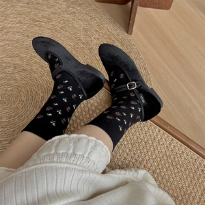 Détail de chaussettes à fleurs vintage avec des ballerines Mary Jane en velours noir