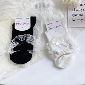 Détail de chaussettes Lolita avec bordure en dentelle délicate et petits nœuds