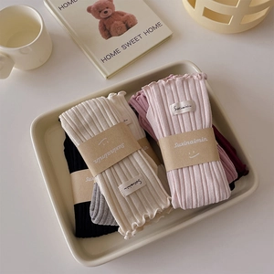 Close-up of ribbed knit socks with lettuce edge trim and brand labels in various colors