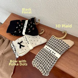 Détails de chaussettes vintage à motifs floraux et pois sur un support en bois clair
