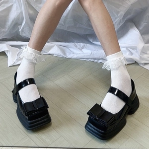 Détail de chaussettes à dentelle Lolita avec des chaussures Mary Jane vernies à plateforme
