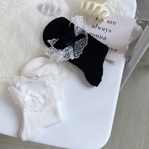 Détail de chaussettes Lolita douces avec dentelle et nœud en satin sur fond blanc