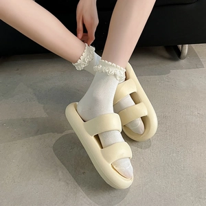 Détail de sandales à plateforme crème portées avec des chaussettes en dentelle blanche