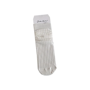 White crew socks with vertical rib knit and bubble ruffled cuffs on plain background