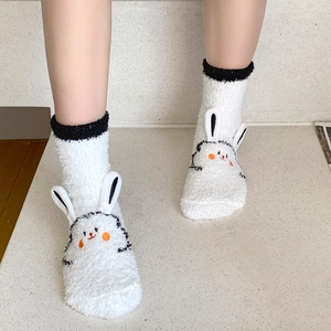 Detailed shot of white coral fleece socks with 3D rabbit ears and cute embroidery