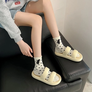 Détail de sandales à plateforme crème avec des chaussettes blanches à pois noirs