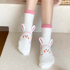 Detail of white fluffy coral fleece socks with 3D bunny ears and cute embroidery