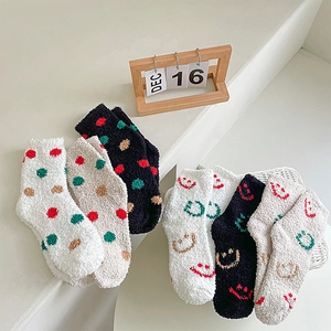 Close-up of soft coral fleece winter socks with cute smile and polka dot patterns