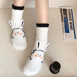 Detailed view of white coral fleece socks featuring 3D rabbit ears and cute facial embroidery