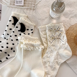 Détails de chaussettes blanches japonaises avec nœuds, pois et volants sur fond texturé