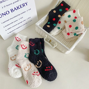 Detail of thick coral fleece socks with smile and polka dot patterns for winter warmth