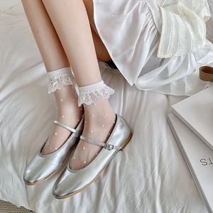 Close-up of silver Mary Jane shoes paired with white lace heart dot mesh socks