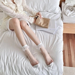 Close-up of white lace trim socks featuring sheer mesh fabric and sweet polka dot details
