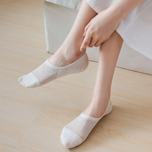 Detail of white breathable mesh low cut invisible socks on feet with stylish vertical stripes