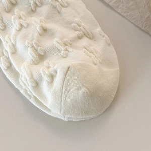 Détail macro de chaussettes blanches avec motif lapin 3D et texture en coton doux