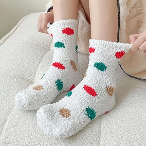 Detailed view of thick white coral fleece socks featuring vibrant colorful polka dots
