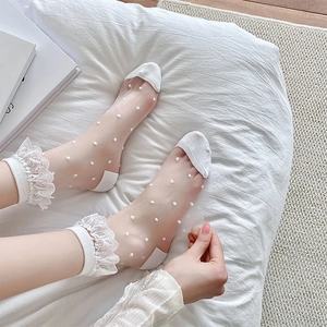 Detail of white lace trim socks with mesh polka dots and elegant ribbon cuffs for women