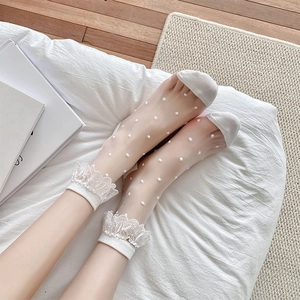 Detail of white lace mesh socks with polka dots and pleated ruffled trim in summer style