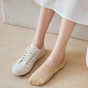Close-up of beige no-show socks with vertical stripes and reinforced toe under canvas shoes