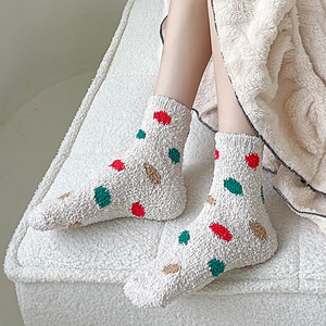 Close-up of thick coral fleece winter socks with colorful geometric patterns and soft texture