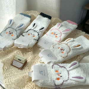 Detailed view of five pairs of plush coral fleece socks with cute cartoon bunny embroidery