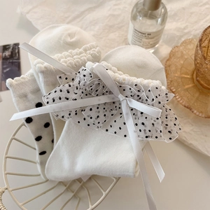 Dettaglio calzini bianchi Lolita con fiocchi di seta, pizzo a pois e volant eleganti