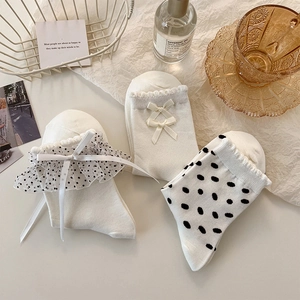 Dettaglio di tre paia di calzini bianchi Lolita in pizzo con pois e fiocchi in rete