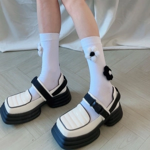Gros plan de chaussures Mary Jane à plateforme avec chaussettes à fleurs et cuir verni