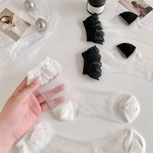 Detail of ultra-thin sheer lace crew socks with ruffled edges in black and white