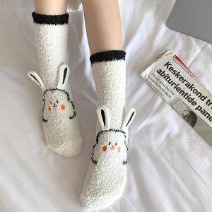 Detail of white coral fleece socks featuring 3D bunny ears and embroidered rabbit face