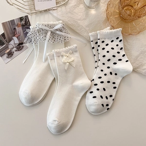 Dettaglio di calzini in pizzo bianco a pois con fiocchi e volant in stile francese