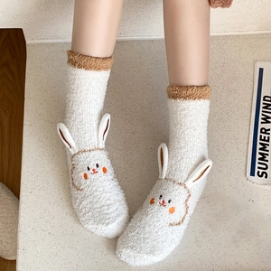 Close-up of white coral fleece socks featuring 3D bunny ears and cute embroidery detail