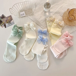 Détail de cinq paires de chaussettes pastel avec bord en dentelle et nœuds en organza