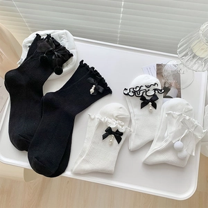 Détail de chaussettes Lolita avec bordure en dentelle, nœuds en satin et perles fines