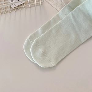 Gros plan sur des chaussettes en maille vert menthe avec texture et coutures