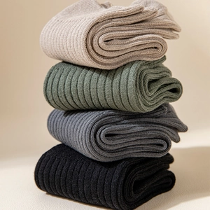 Detailed view of four pairs of ribbed vertical knit thick socks in various solid colors