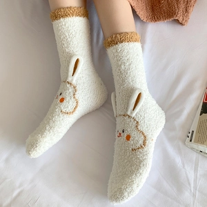 Detail of white coral fleece socks featuring 3D rabbit ears and cute cartoon embroidery