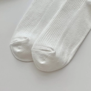 Gros plan sur la texture en maille côtelée blanche et la couture lisse des chaussettes