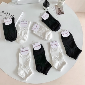 Flat lay of sweet black and white crew socks with floral patterns and ruffled edges