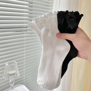 Détails des revers à volants avec nœuds et pompons sur des chaussettes Lolita