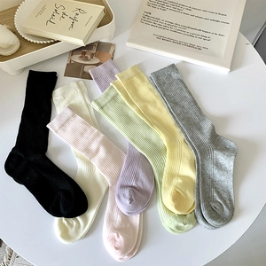 Détail de chaussettes mi-mollet en maille côtelée de sept couleurs pastel sur table