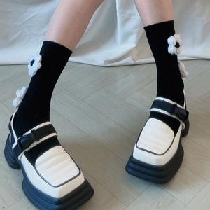 Détail de mocassins à plateforme bicolores avec bout carré et texture matelassée