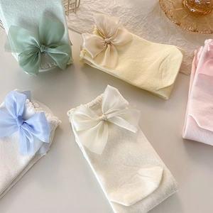 Gros plan de chaussettes pastel avec nœuds en satin élégants aux couleurs macaron doux