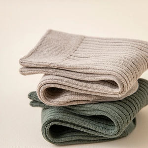 Detail of ribbed knit texture on cream and olive green cotton crew socks for men