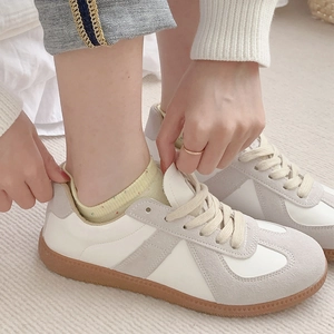 Close-up of candy-colored dot yarn boat socks with retro white leather sneakers