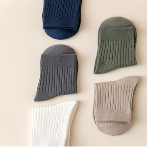 Flat lay of five pairs of rib-knit crew socks in navy, grey, olive, beige, and white