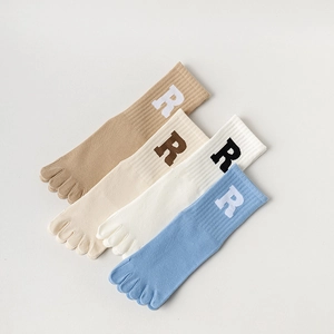 Makroansicht von vierfarbigen Yoga-Socken mit einem markanten R-Buchstabendesign