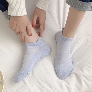 Detail of light blue low cut ankle socks with rainbow dot pattern and mesh texture